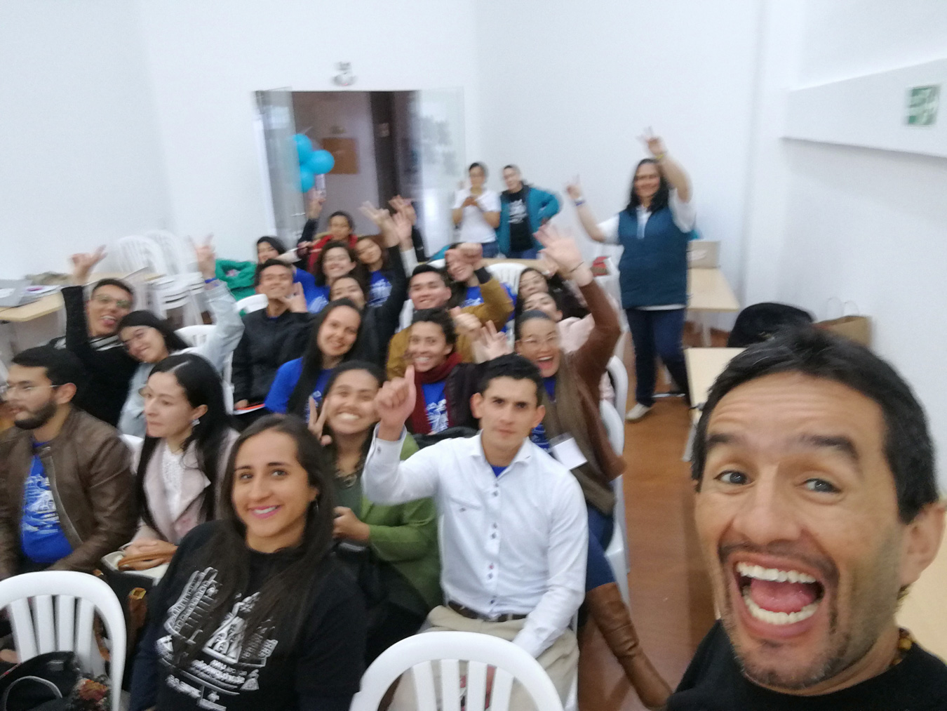 Edwin Bernal riendo con un grupo en un taller